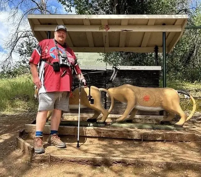 An archer at a shooting shelter with two life-size 3D animal targets down the track.