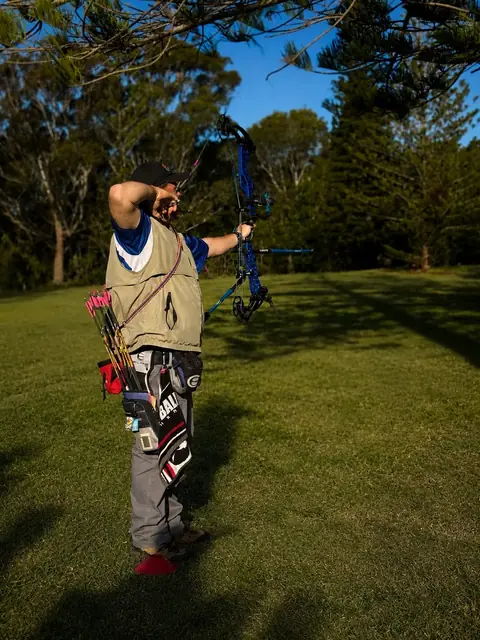 An archer walking down the lane to pull arrows, bow at their side.