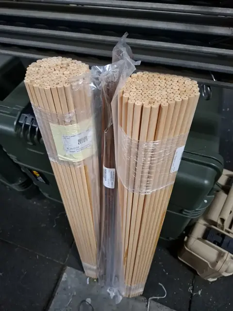 A bundle of wooden arrow shafts.