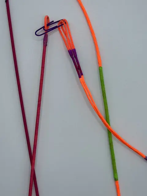 A finished set in Flo Orange with Flo Purple serving, coiled on white.