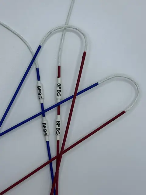 A finished set in White with Red & Royal Blue serving, coiled on white.