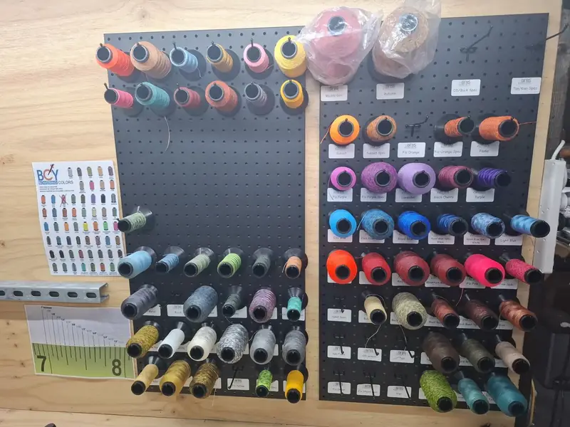 The spool wall: every string colour on the chart, on its own peg.