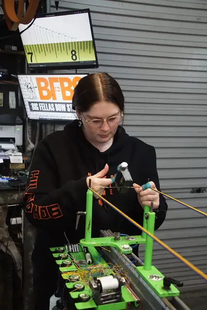Winding a string on the jig beside the measuring board.