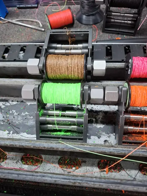 Orange and black strands laid up on the jig.