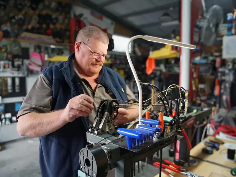 Tim working on a compound bow in the press at the Argenton workshop.