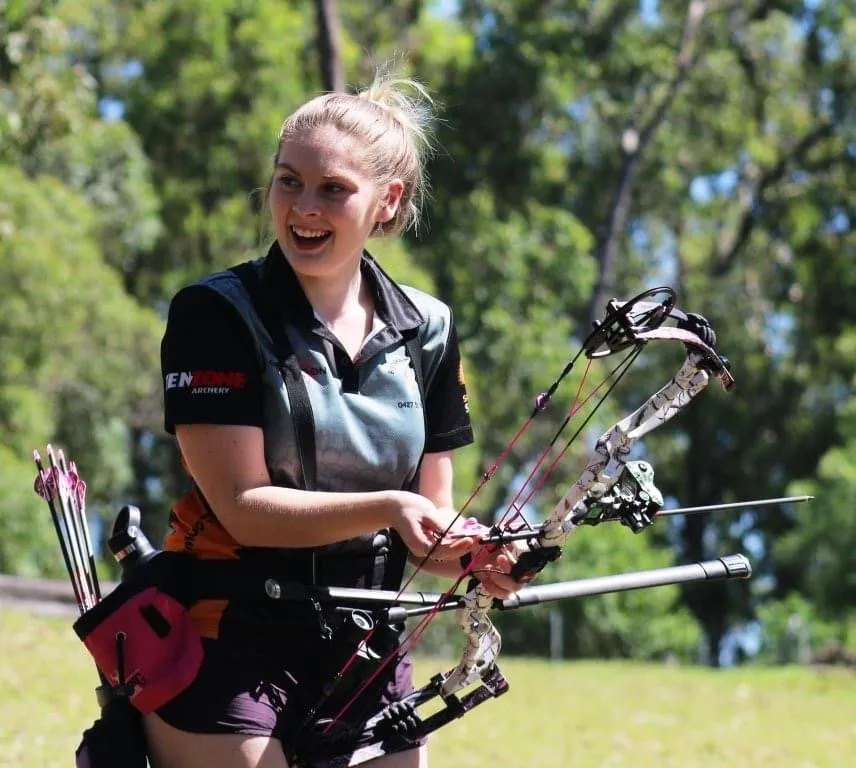 Jordan Richards holding her compound bow at a field shoot.