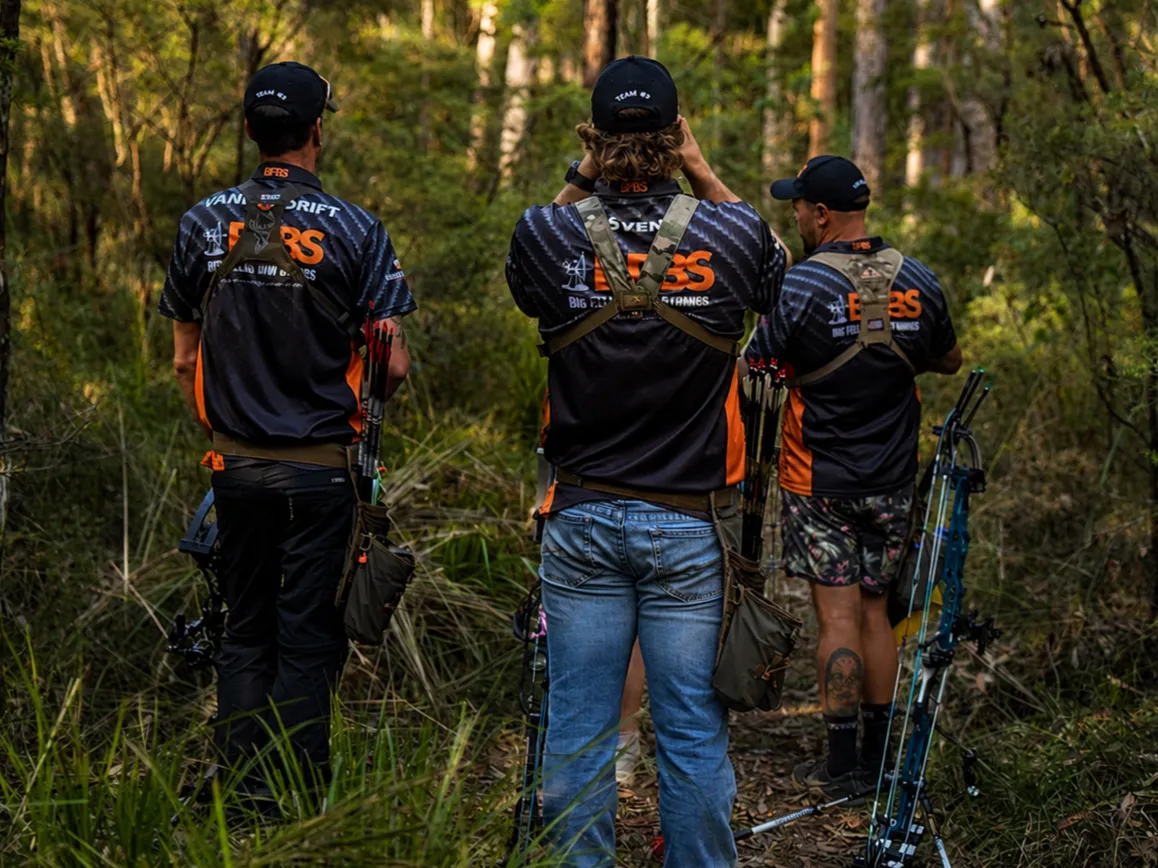 Three Big Fella's team shooters walking into the bush, bows on their backs.