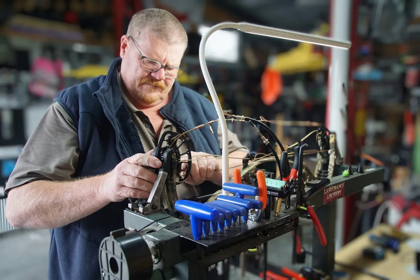 Tim working on a compound bow in the press.